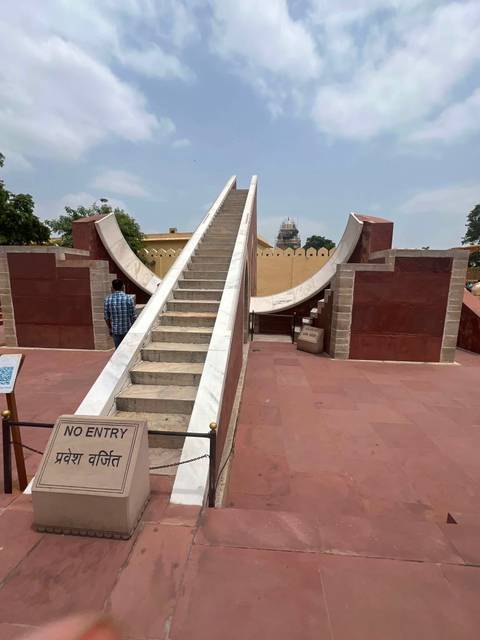       Marble stair sundial structure at Jantar Mantar observatory with ‘No Entry’ sign in foreground.
  