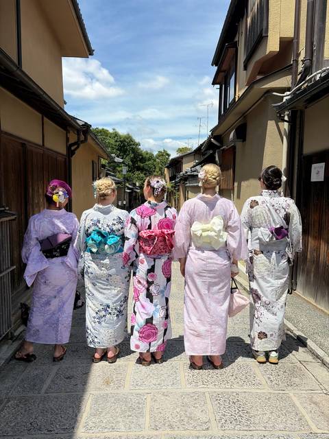       Same group of kimono-clad travelers shown from behind on a historic Kyoto street.
  
