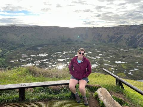       Traveler sits on a bench overlooking the vast volcanic crater lake of Rano Kau on Easter Island.
  