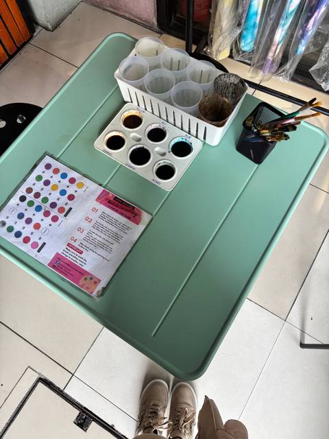       Small tabletop art setup with colourful paint tray and printed instructions
  