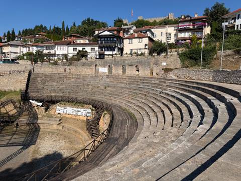       Stone tiers of the ancient Hellenistic theatre of Ohrid curve around the stage remains.
  