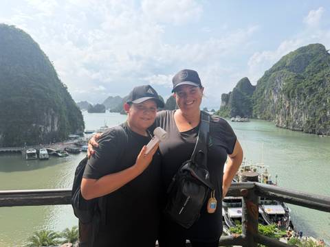       Mother and son on a viewpoint railing overlooking the emerald karsts of Ha Long Bay
  