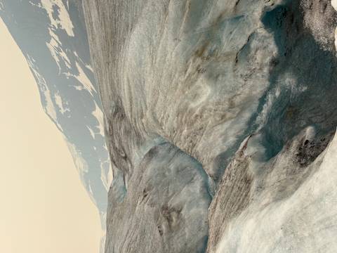       Expansive glacier landscape with winding meltwater channels and distant snow-capped ridges.
  