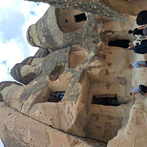       Tourists explore cave dwellings carved into soft rock formations in Cappadocia.
  
