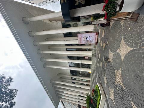       Modern neoclassical building with tall white columns and a poster advertising La Traviata at its entrance.
  