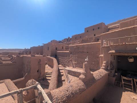       Adobe kasbah buildings and narrow alleyways under bright blue sky at the fortified village of Ait Benhaddou
  