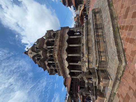       Stone pagoda-style Nyatapola Temple against blue sky in Bhaktapur Durbar Square.
  