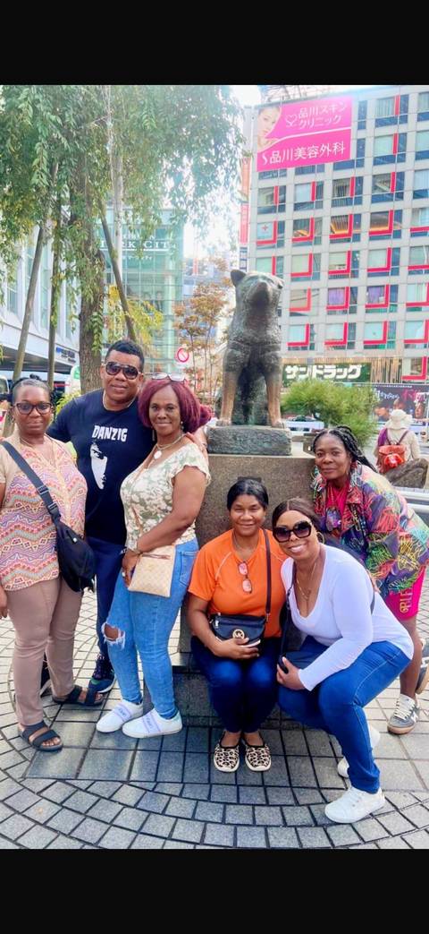       Travelers posing around the famous Hachiko statue in Shibuya.
  