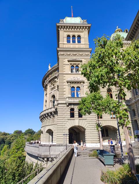       Detailed exterior of the Federal Palace of Switzerland with bright blue sky backdrop.
  