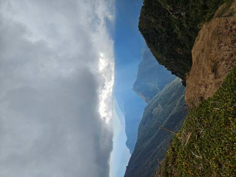       Dramatic Andes vista with layered mountain ridges under heavy clouds and sunbeams.
  