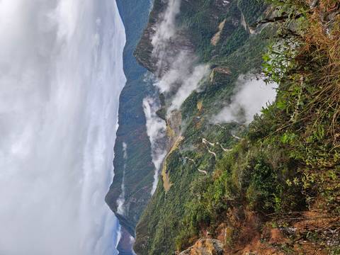       Clouds drifting through the verdant mountainsides and switchback road approaching Machu Picchu.
  
