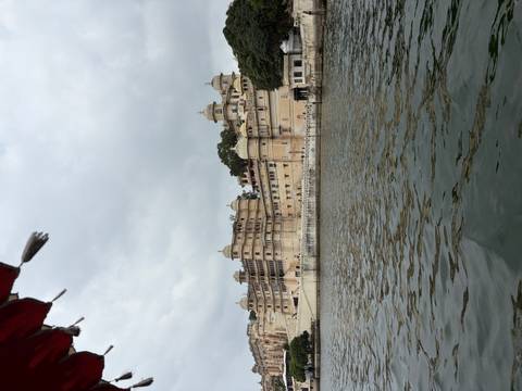       Lakeside view of grand Udaipur City Palace complex reflected in still waters.
  