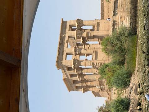       Elegant Greco-Roman style temple ruins on an island, viewed from a boat on the Nile.
  