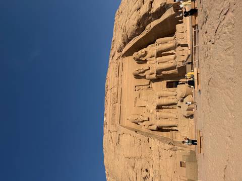       Great Temple of Abu Simbel carved into a sandstone cliff, statues illuminated by low morning sun.
  