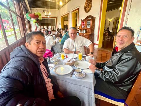       Three men having breakfast at a traditional restaurant table.
  