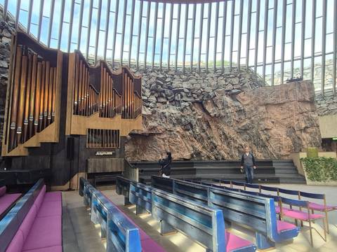       Rock-hewn interior of Helsinki’s Temppeliaukio Church with striking pipe organ and natural stone walls.
  