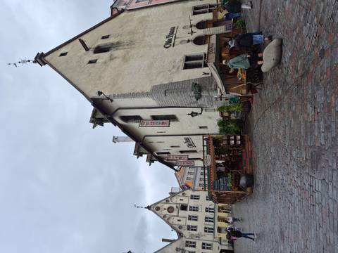       Medieval-style restaurant and stone buildings on a wet cobblestone street in Tallinn’s Old Town.
  