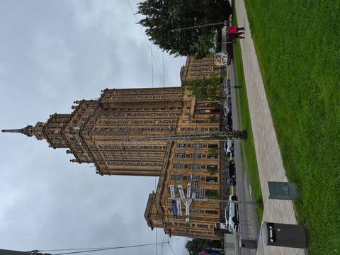       Tall Soviet-era Latvian Academy of Sciences tower rising above a grassy square on a gray day.
  