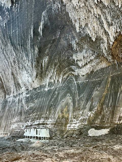       Abstract streaks and stalactite formations on a huge salt mine wall surface.
  