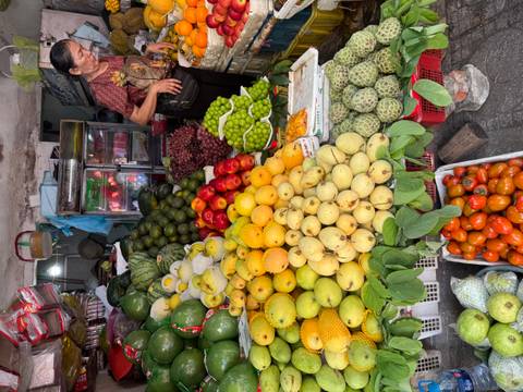       Colorful fruit and vegetable stall overflowing with produce at Vietnamese market
  