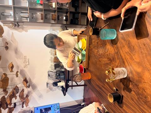       Instructor pours coffee into colourful cups during a hands-on brewing class.
  