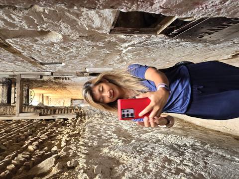       Woman snaps a selfie in a narrow, rough-plastered alley of an old medina.
  