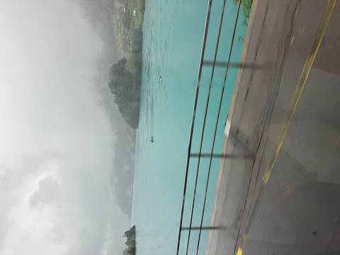       Misty turquoise lake seen through bus window on a rainy day
  