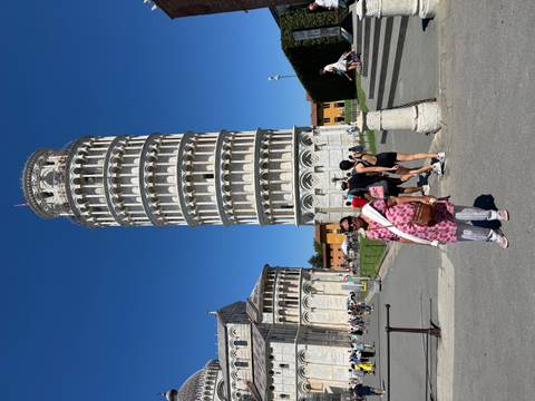       Traveller standing before the Leaning Tower of Pisa on a bright summer day
  