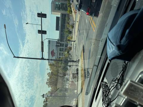       Blurry view through car windshield of city street and stadium sign
  