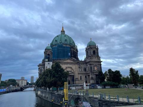       Berlin Cathedral with scaffolding around the dome under a moody evening sky.
  