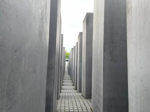       Narrow concrete corridors of Berlin’s Holocaust Memorial leading into the distance.
  