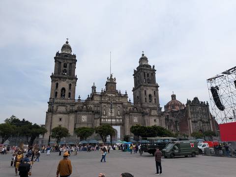       Front façade of Mexico City's Metropolitan Cathedral towering over the busy Zócalo square
  