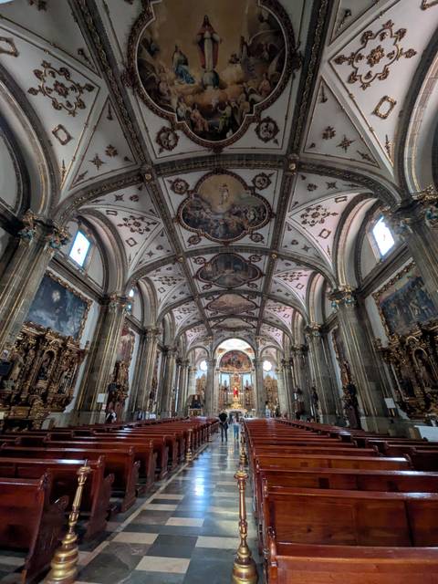       Lavishly decorated church interior with ornate ceilings, arches and gilded altarpieces
  