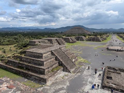       Panoramic view over the Avenue of the Dead and pyramids at Teotihuacán with visitors exploring
  