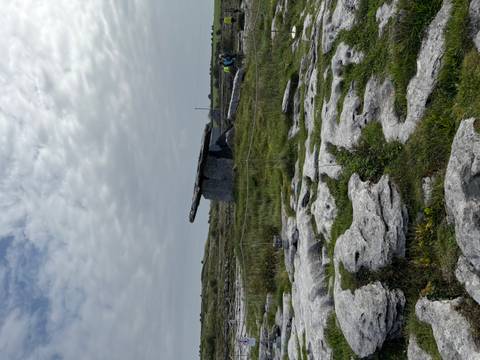       Megalithic Poulnabrone dolmen standing on a limestone karst landscape under a mottled sky.
  