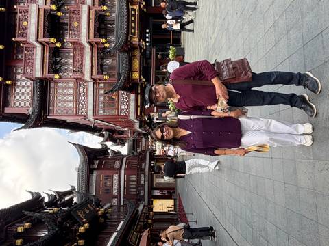       Older couple posing on the same traditional Shanghai pedestrian street with ornate wooden facades
  