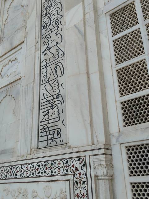       Black marble calligraphy inlaid on the pristine white marble wall of the Taj Mahal.
  