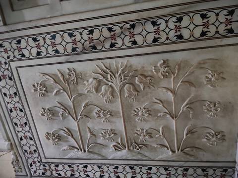       Detailed marble relief of flowering plants and vines inlaid with semi-precious stones.
  