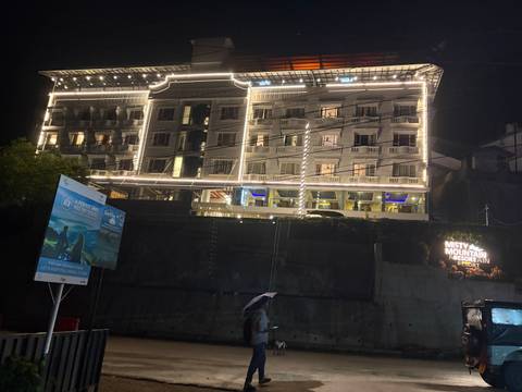       Multi-storey hotel building outlined with decorative white lights against the night sky.
  
