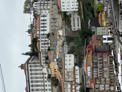       Tall, colourful riverfront buildings cascade down Porto’s hillside toward the Douro River on a cloudy day.
  