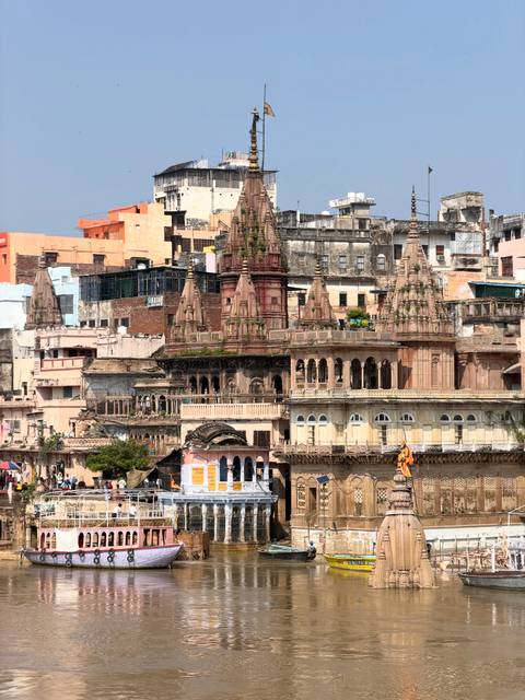       Intricately carved temple spires and old riverside palaces stacked across Varanasi’s ghats.
  