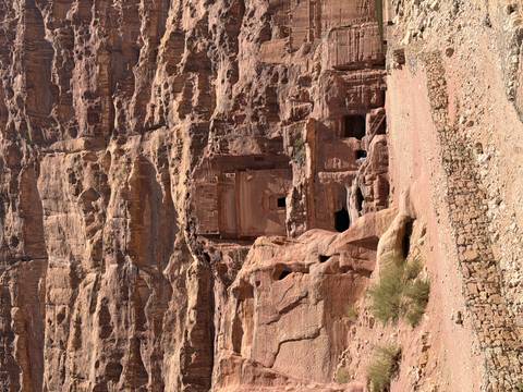       Rock-hewn façade of a lesser tomb blends into the rose-red cliffs of Petra.
  