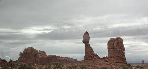       Iconic Balanced Rock formation rising against an overcast sky in a desert landscape
  