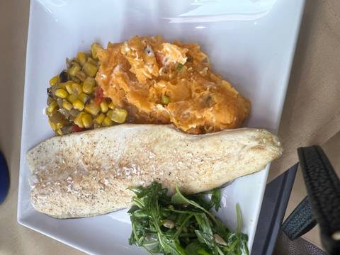       Plate featuring grilled white fish, mashed sweet potatoes, corn medley and fresh greens
  