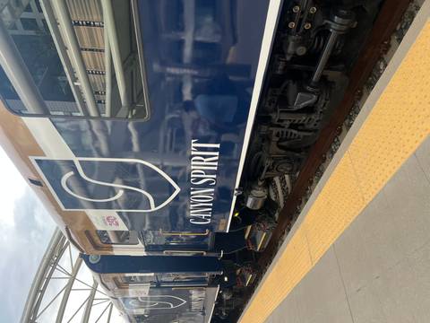       Blue and white passenger railcar labeled 'Canyon Spirit' at a station platform
  