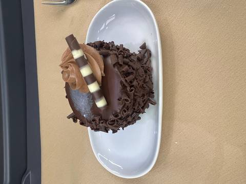       Indulgent individual chocolate cake with curls and decorative swirl on a plate
  