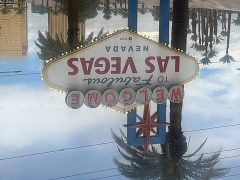       Iconic "Welcome to Fabulous Las Vegas, Nevada" roadside sign with palm trees and a partly cloudy sky.
  