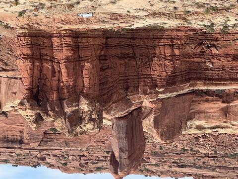       Close-up of layered red rock cliffs and formations in a desert canyon.
  