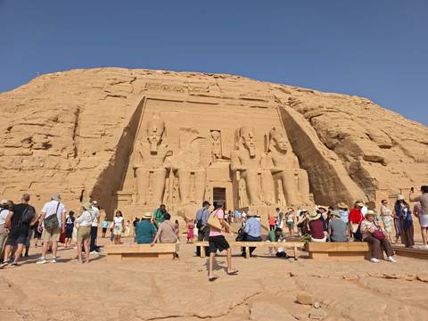       Crowds gather before the colossal seated statues carved into Abu Simbel’s sandstone cliff face.
  