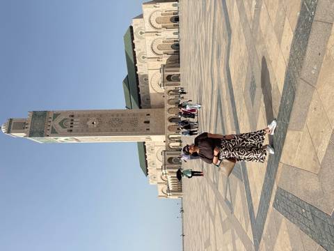       Traveler poses in wide plaza before Casablanca’s Hassan II Mosque.
  